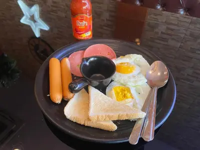 a plate of breakfast food with eggs and toast at Baanpin Hotel in Bangkok
