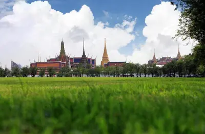 a green field with a building in the background at Baanpin Hotel in Bangkok