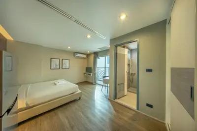 a bedroom with a bed and a room with a hallway at Ralph Poshtel Pratunam in Bangkok