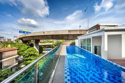 a swimming pool on the roof of a building with a bridge at Ralph Poshtel Pratunam in Bangkok