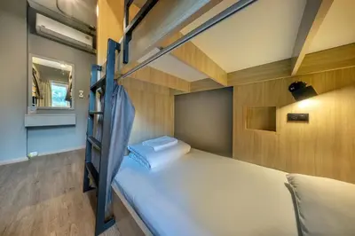 a bedroom with two bunk beds and a mirror at Ralph Poshtel Pratunam in Bangkok