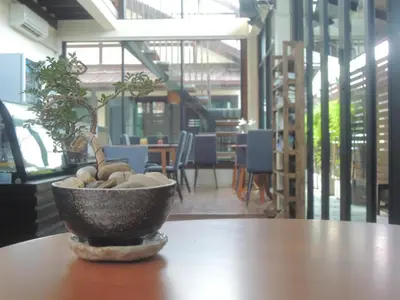 a potted plant sitting on top of a wooden table at Aiims Tales Canal Boutique House in Bangkok