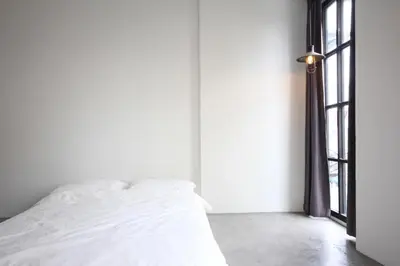 a white bed in a room with a window at L22 HOSTEL in Ban Khlong Samrong
