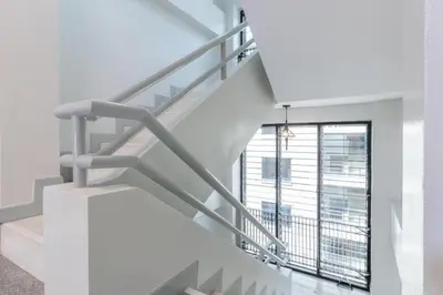a staircase in a building with a large window at OYO 818 Suksomboon Residence in Bangkok