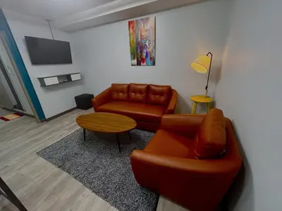 a living room with a couch and a table at SkyLink Homes - Pattunaam - Airport Link & BTS Chidlom in Bangkok