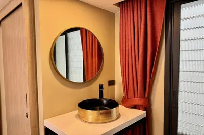 a bathroom with a sink and a mirror at Parcel Hotel Bangkok in Bangkok