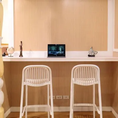 two white stools sitting at a counter with a laptop at Rere Hostel - รีรีโฮสเทล in Bangkok