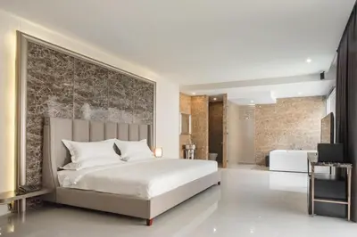 a bedroom with a large bed and a bathroom at The Valen Resort in Bangkok