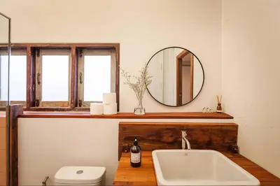 a bathroom with a sink and a mirror and a toilet at Mana Craft Stay in Bangkok