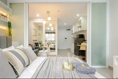 a living room with a large white couch and a living room at Sense of London BTS Baring in Ban Khlong Samrong