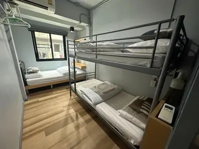 a room with three bunk beds and a window at Bangkok Silom chat box hostel in Bangkok