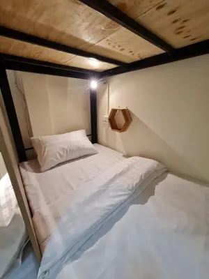 a small bed in a small room with avertisementatronatronstrationstrationstrationstration at De Chalet in Bangkok