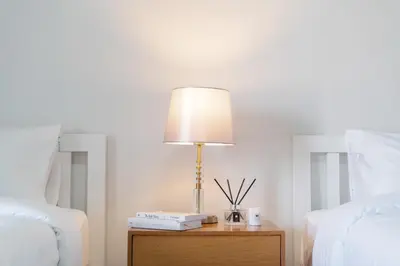 a lamp on a table next to a bed at Nicha Residence Hotel in Bangkok