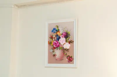 a picture of a vase of flowers on a wall at Nicha Residence Hotel in Bangkok