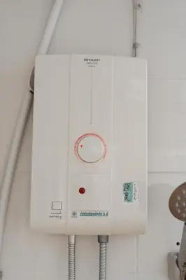 a white machine is hanging on a wall at Nicha Residence Hotel in Bangkok