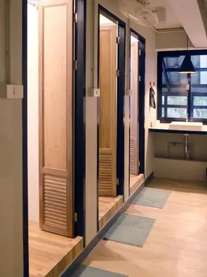 a room with a row of glass doors and a kitchen at Monomer Hostel Bangkok in Bangkok