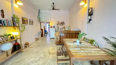 a living room with a wooden table and a kitchen at Baan YentaFo - Pink House 2nd floor in Chinatown