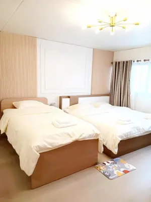 a bedroom with two beds and a window at NK hostel 18 in Thung Si Kan