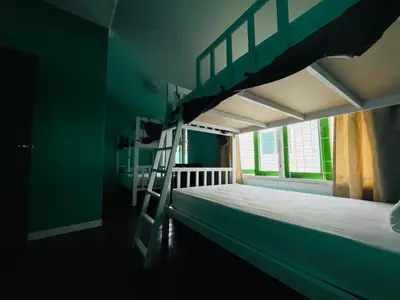 a bedroom with a bunk bed with a ladder at Green Garden Hostel in Bangkok