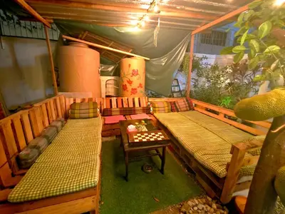 a room with a tent with two beds and a table at Green Garden Hostel in Bangkok