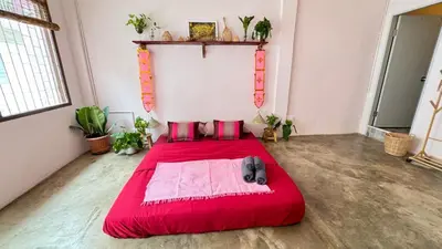 a bedroom with a red bed in a room at Baan YentaFo - Pink House 3rd floor in Chinatown