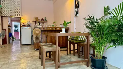 a kitchen with a table and some potted plants at Baan YentaFo - Pink House 3rd floor in Chinatown