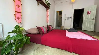 a large red bed in a room with plants at Baan YentaFo - Pink House 3rd floor in Chinatown