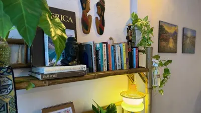 a book shelf with books on top of it at Baan YentaFo - Pink House 3rd floor in Chinatown