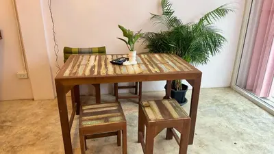 a wooden table with two chairs and a table with plants at Baan YentaFo - Pink House 4th floor in Chinatown