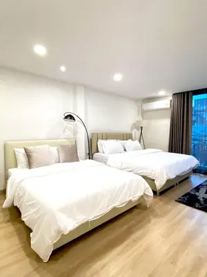 two beds in a room with white sheets at 4Beds 4Baths New Renovated Entire House BTS Ekkamai in Bangkok