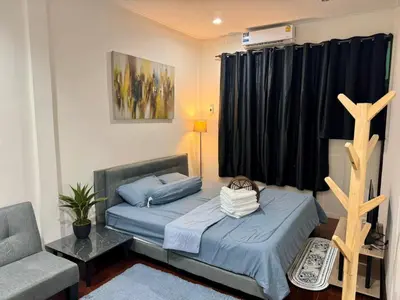 a bedroom with two beds and a chair and a window at Twenty One Place in Bangkok
