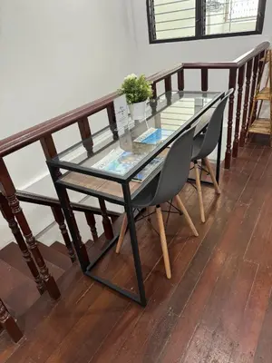 a glass table and chairs on a wooden floor at Twenty One Place in Bangkok