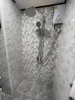 a shower in a bathroom with a tiled wall at Twenty One Place in Bangkok