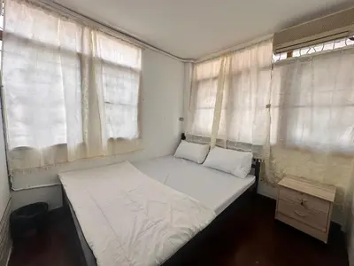 a small bed in a room with two windows at Yuma Tashi Hostel in Bangkok