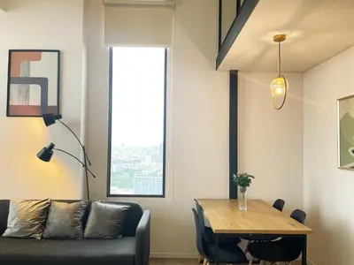 a living room with a couch and a table at 2BR BTS On Nut Siamese87 Two Bedroom LOFT hight floor 24 in Bangkok