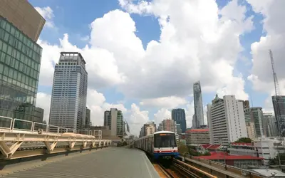 a train on a track in a city with buildings at Sleep cafe @ Hidee in Bangkok