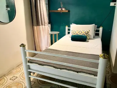 a bed in a room with a green wall at Sleepinn Bang Chak in Bangkok
