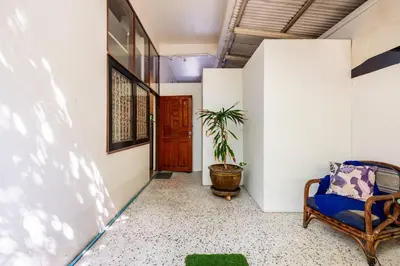 a hallway with a chair and a wooden door at Sleepinn Bang Chak in Bangkok