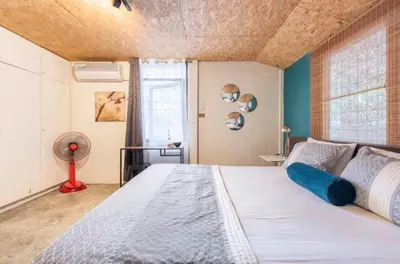 a bedroom with a large bed and a window at Sleepinn Bang Chak in Bangkok