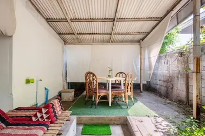 a patio with a table and chairs and a couch at Sleepinn Bang Chak in Bangkok