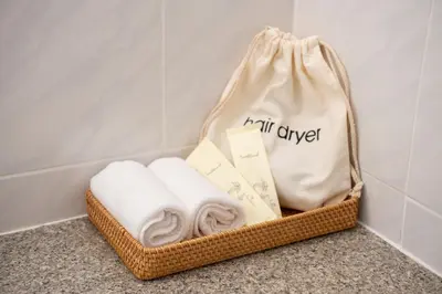 a basket with towels and a bag on a counter at BUA Suite Sukhumvit, Nana BTS in Bangkok