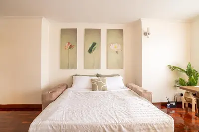 a bedroom with a bed and a couch at BUA Suite Sukhumvit, Nana BTS in Bangkok