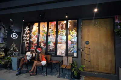 two people sitting in front of a restaurant at BED STATION Hostel Ratchthewi in Bangkok