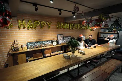 a group of people sitting at a counter in a restaurant at BED STATION Hostel Ratchthewi in Bangkok