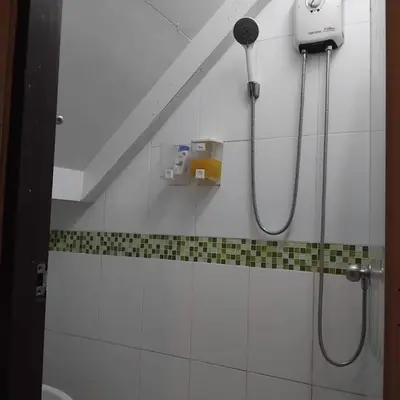 a bathroom with a shower with a blow dryer on the wall at Sleep at home hostel in Bangkok