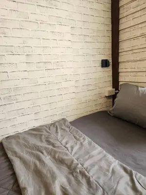 a bed in a room with a brick wall at 207-Olan Place Homely room Free Wi-Fi and Near BTS line in Bangkok