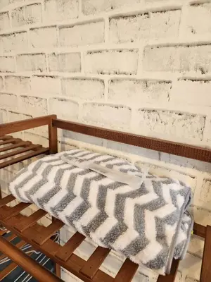 a bed in a room with a white brick wall at 207-Olan Place Homely room Free Wi-Fi and Near BTS line in Bangkok