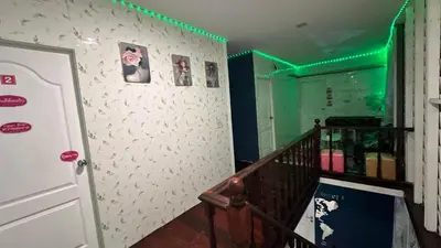 a room with a staircase with green lights on the wall at White House Hostel Khaosan in Bangkok