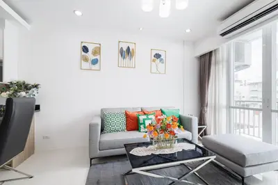 a living room with a couch and a table at Shine Sukhumvit 43 Apathotel Phrompong in Bangkok