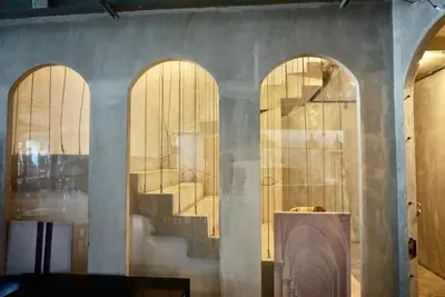a room with three arched doors and a staircase at Silom Soi 3 Hash Apartment in Bangkok